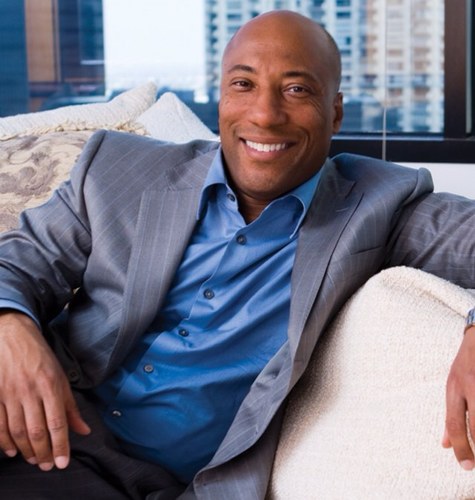 Byron Allen sitting on white couch